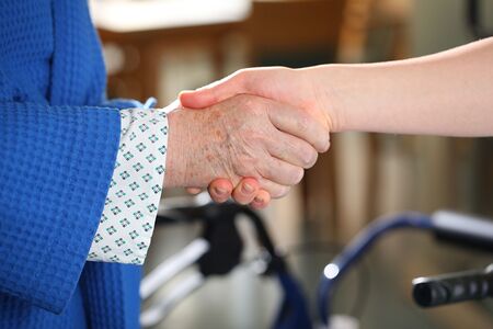 Patientin und Ärztin oder Pflegerin reichen sich die Hand
