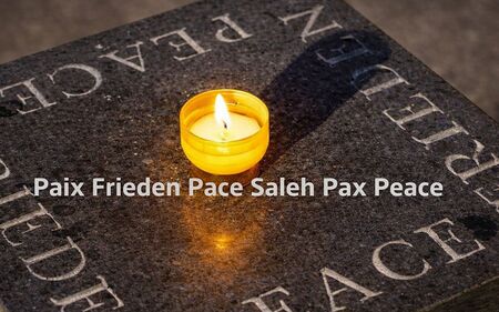 Kerze mit Aufschrift Friede in verschiedenen Sprachen