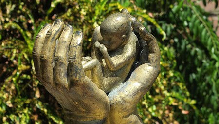 Embryo mit schützenden Händen