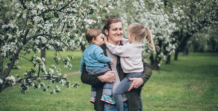 Vater mit zwei Kindern im Arm